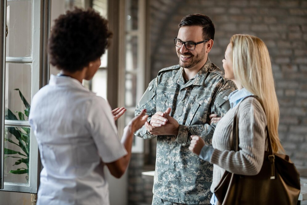 happy-army-soldier-his-wife-communicating-with-african-american-healthcare-worker-while-having-consultations-clinic_637285-1792 veteran transportation services to va in houston